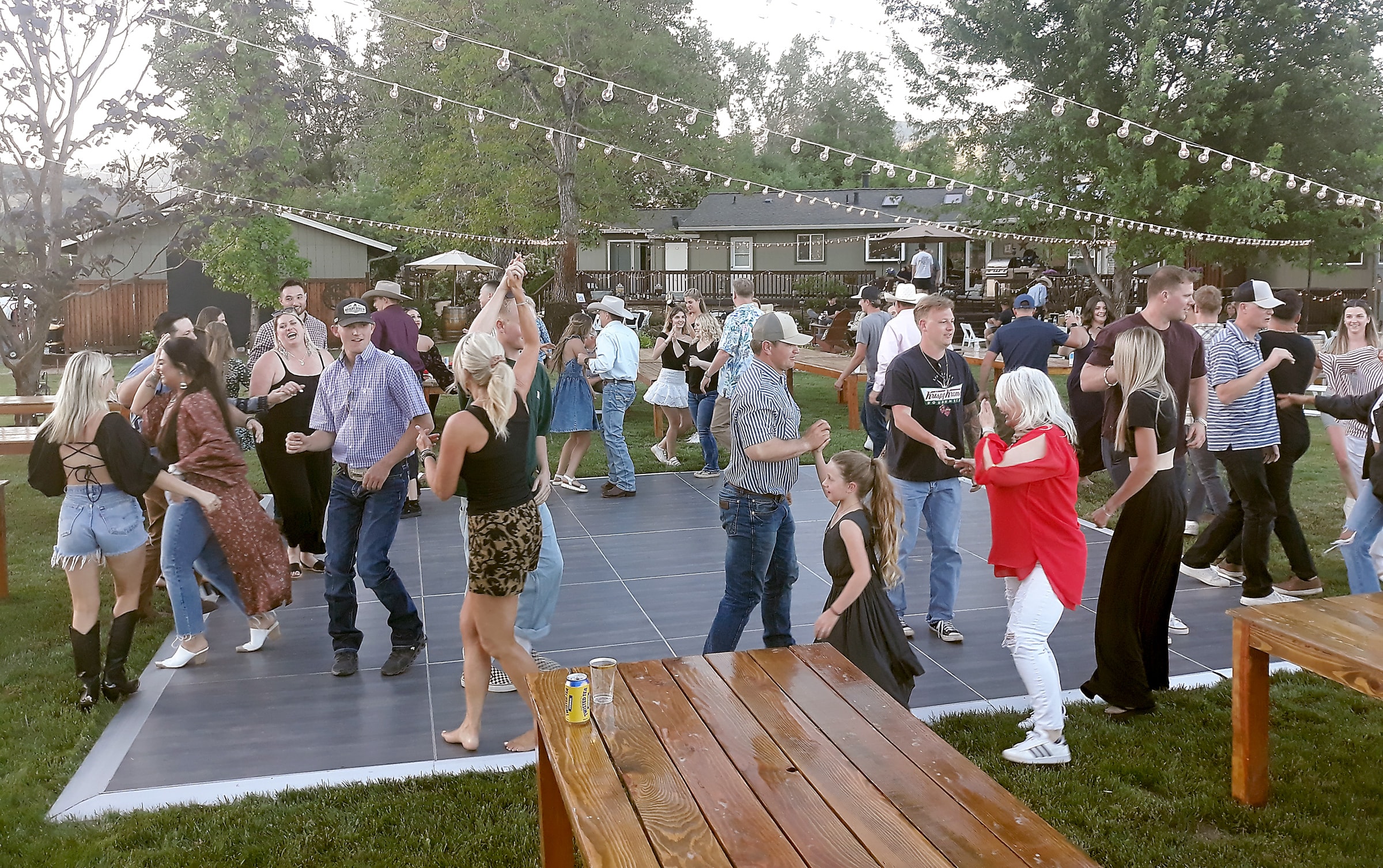 Outdoor wedding rehearsal party barn dance under string lights in Northern California