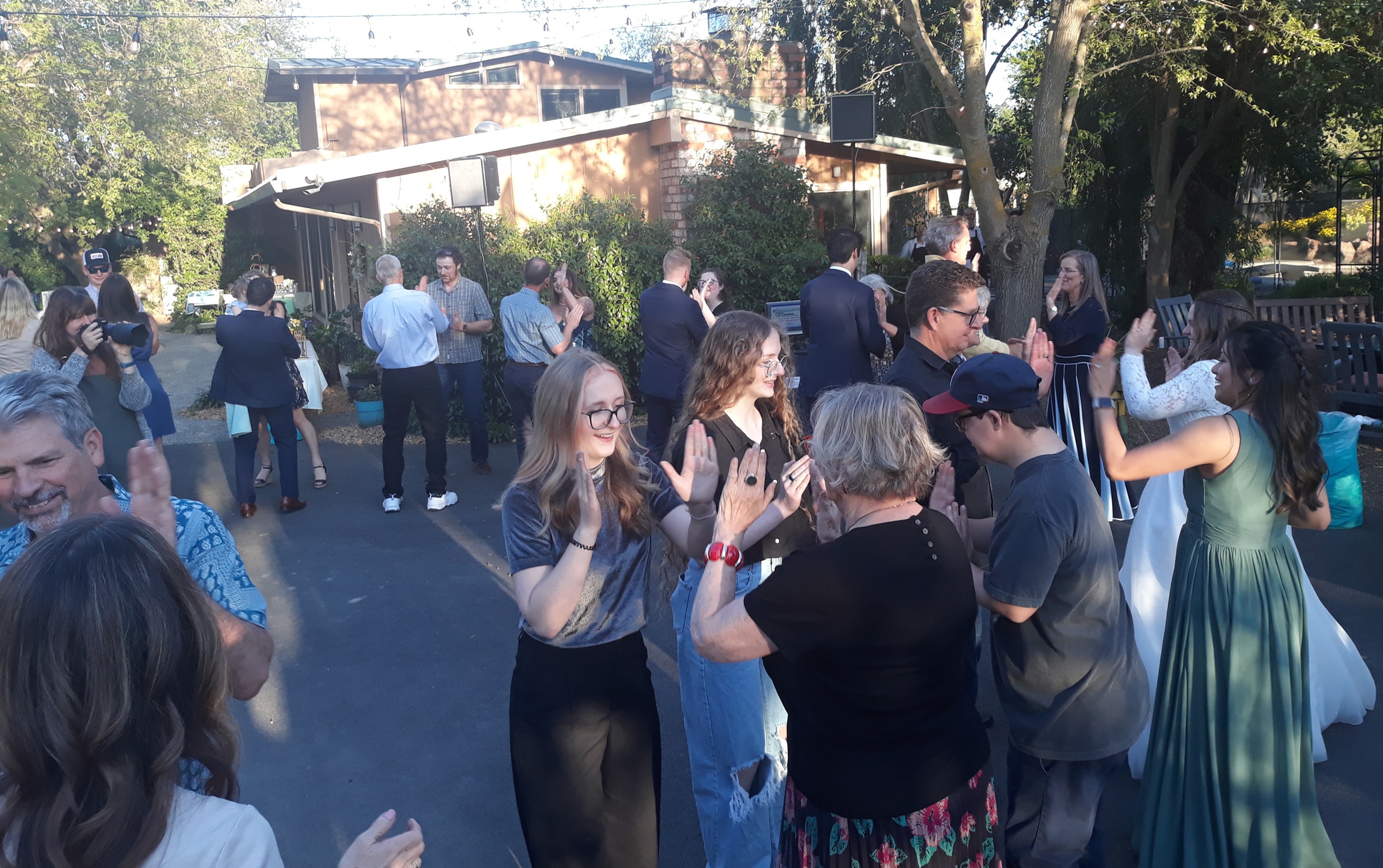 Outdoor courtyard wedding reception with guests in a barn dance mixer in Northern California