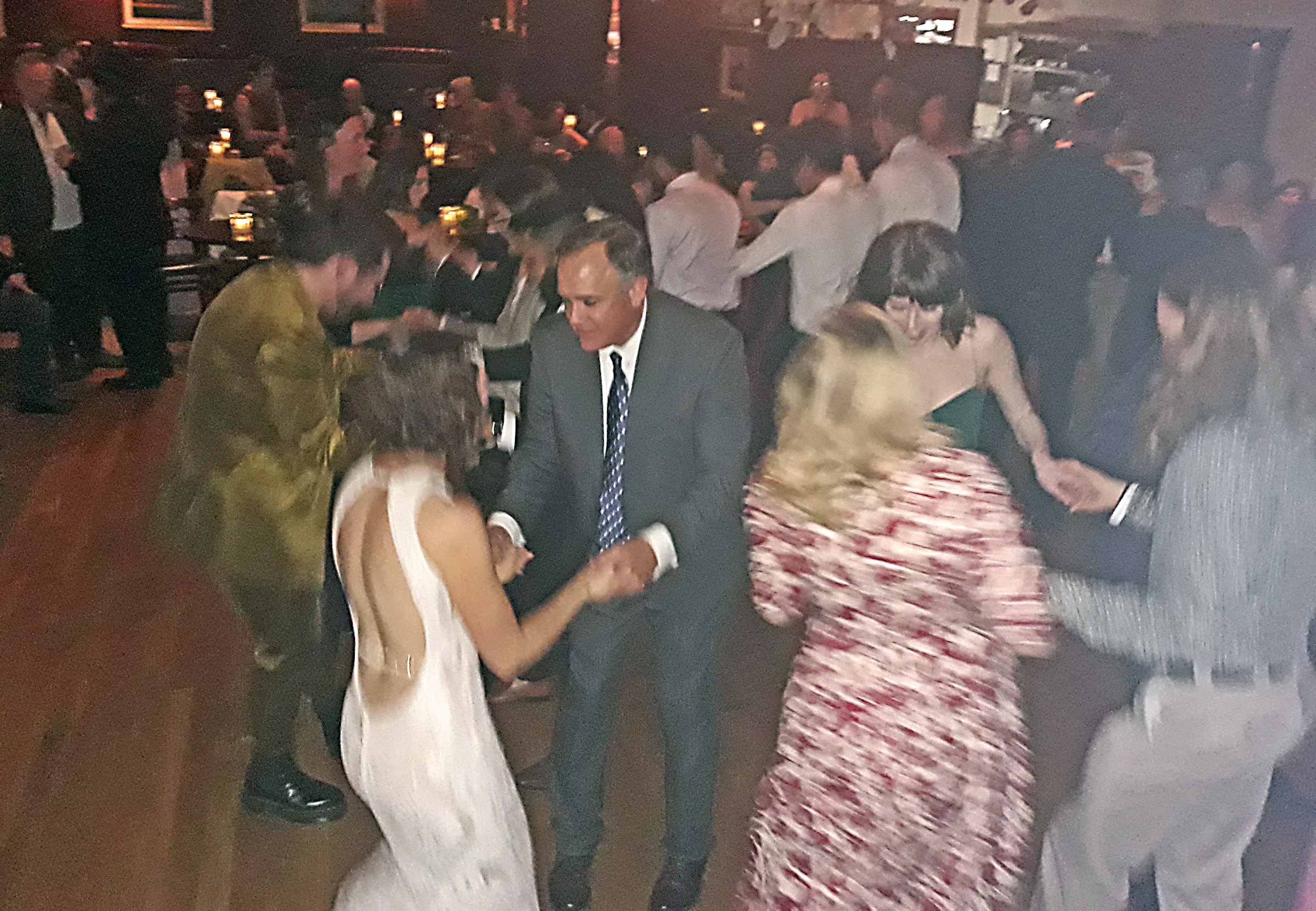 Couples dancing energetically at a barn dance segment in an upscale pub-style wedding venue in Northern California