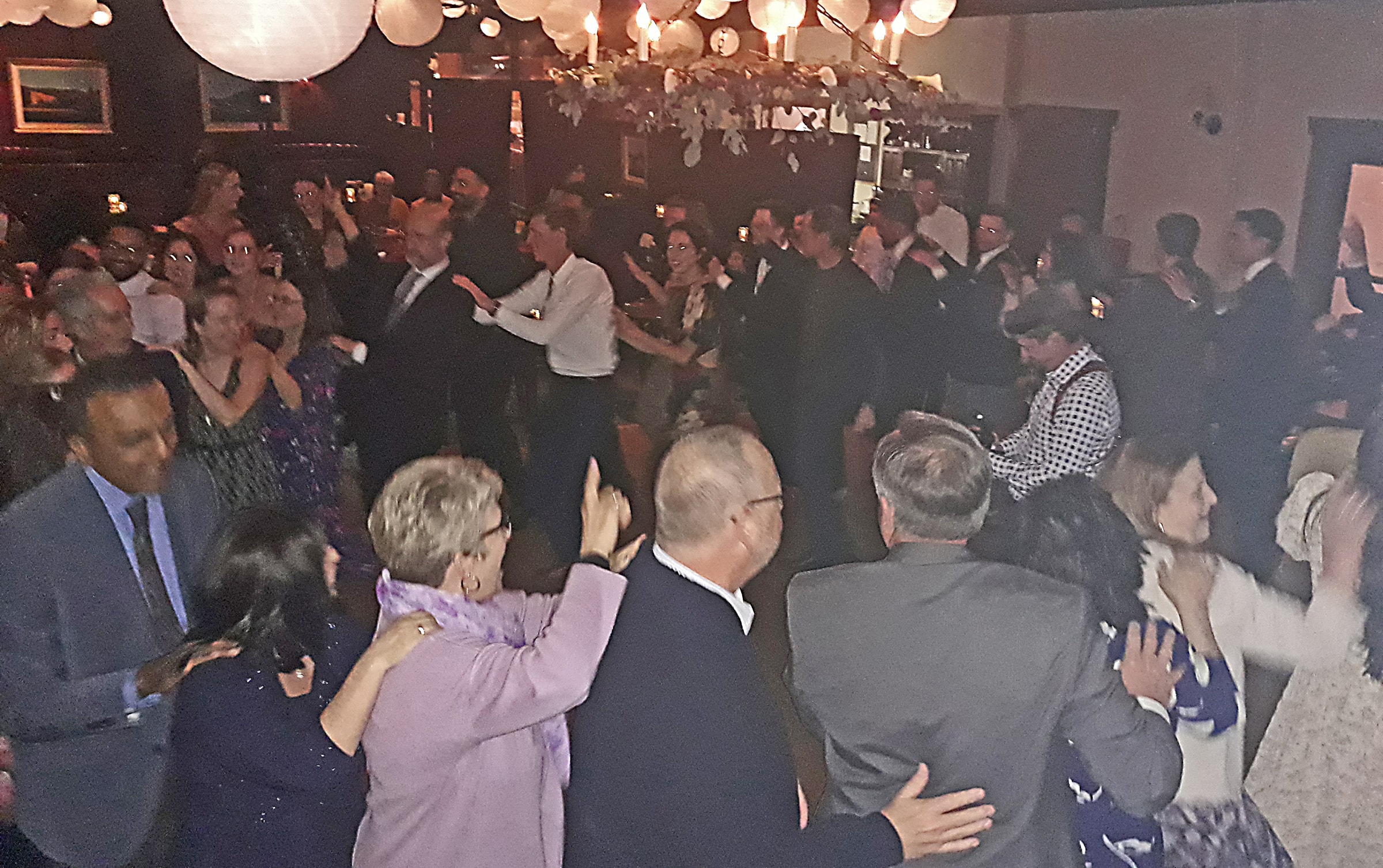 Wedding party and guests doing a conga line in an industrial-chic venue in Northern California