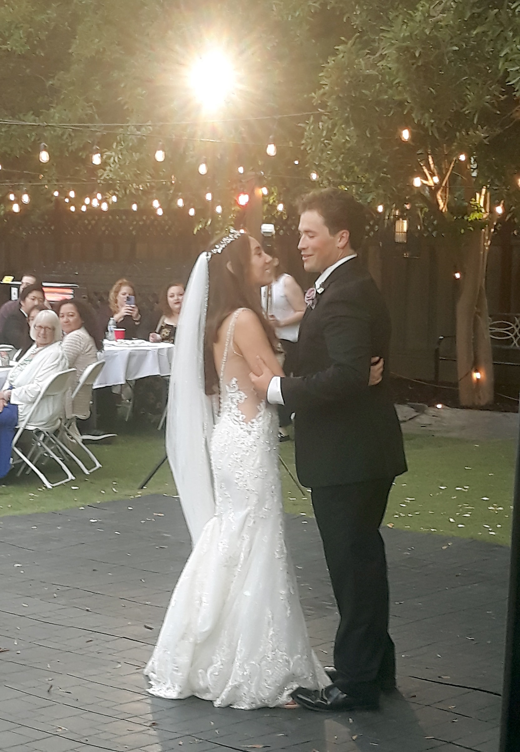 Bride and groom sharing an outdoor first dance under string lights at a Northern California wedding reception