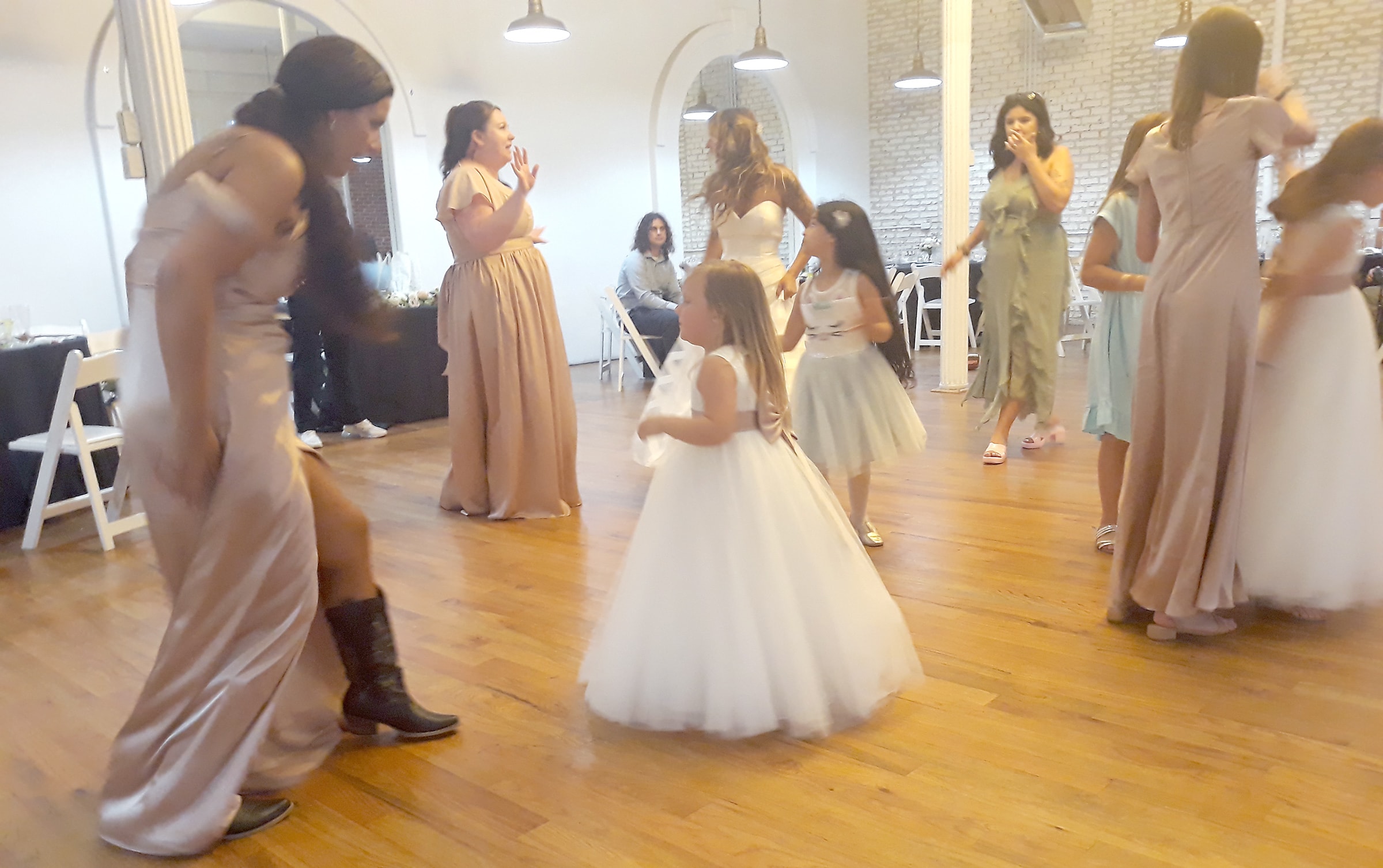 Flower girls and bridesmaids dancing joyfully together at a wedding reception in Northern California