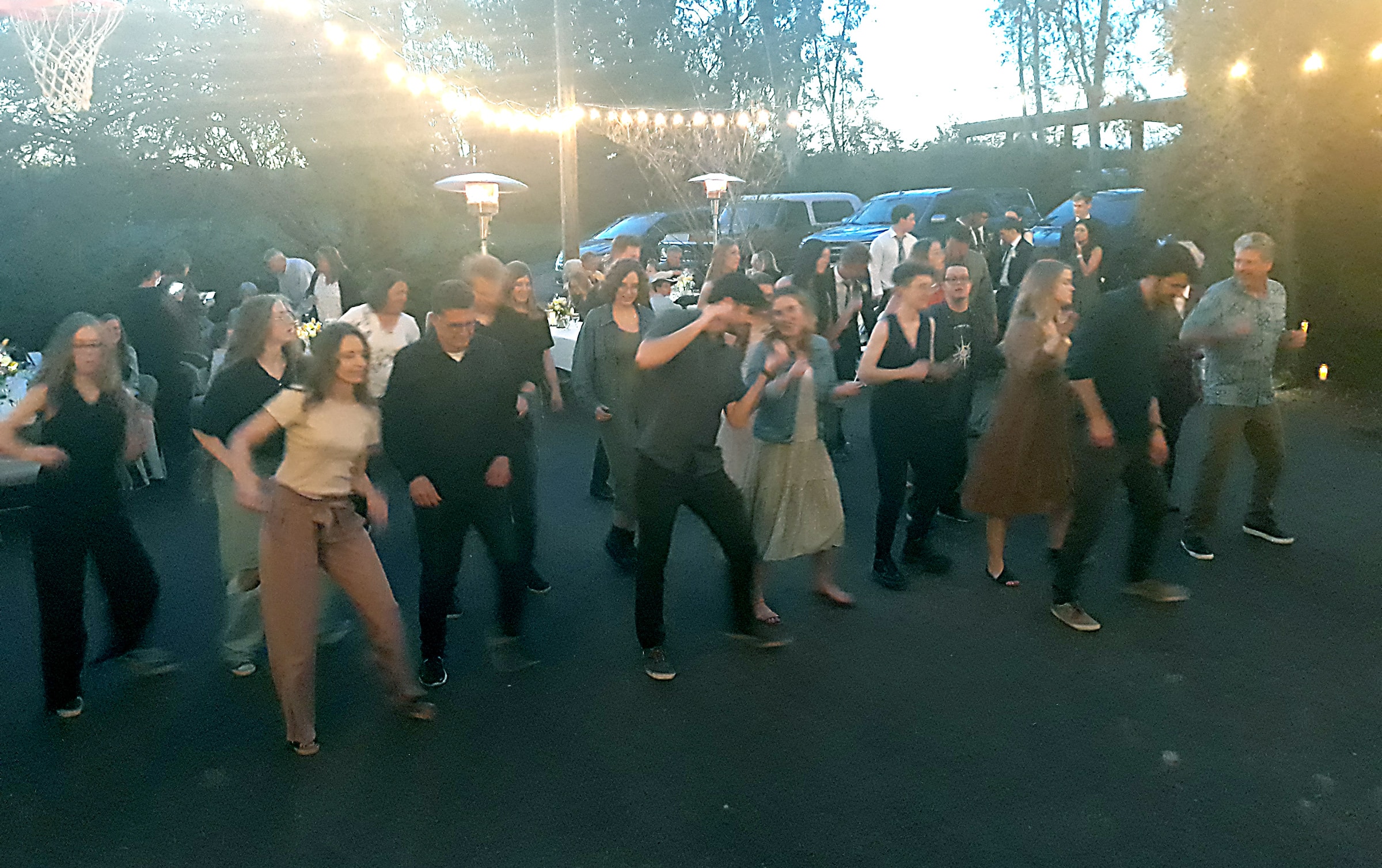 Packed wedding reception dance floor with guests doing a novelty group dance in Northern California