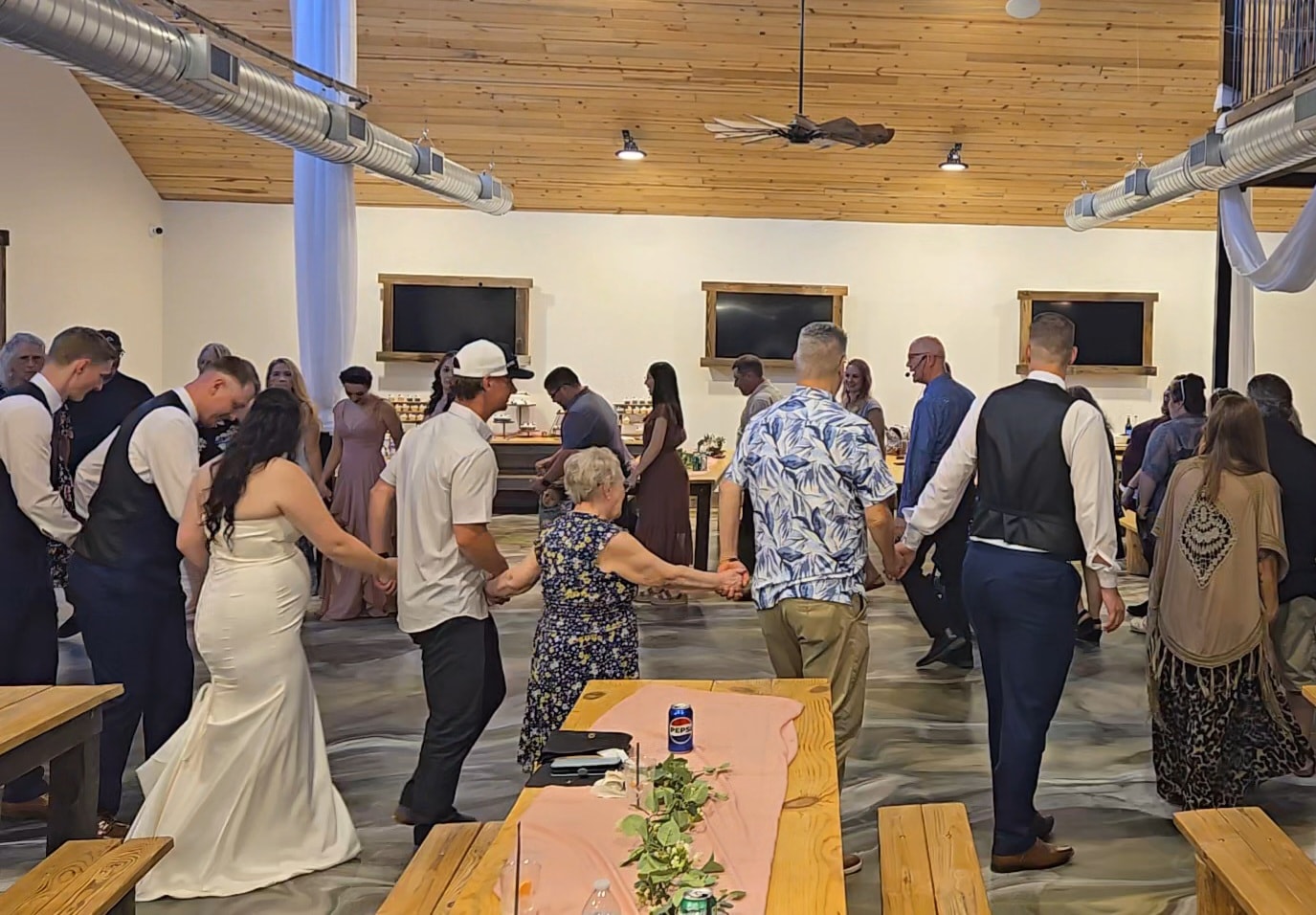 Guests joining hands in a joyful circle dance at a wedding celebration