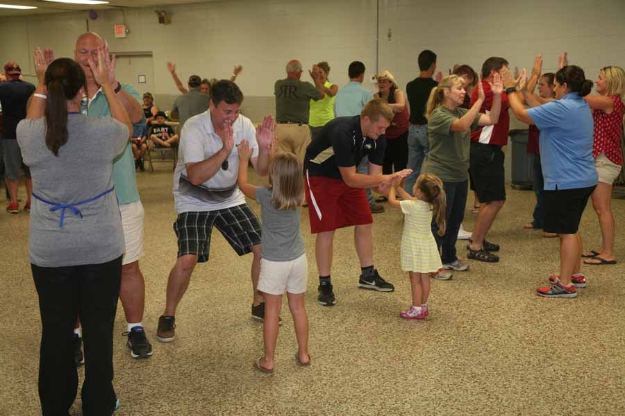 People square dancing in a rustic hall